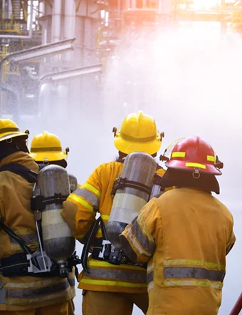 a group of firemen wearing yellow helmets